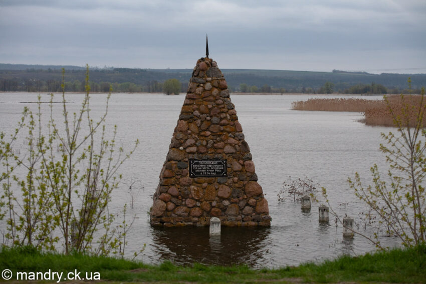 Пам'ятний знак у вигляді кам'яної піраміди біля села Межиріч під час повені в долині Росі